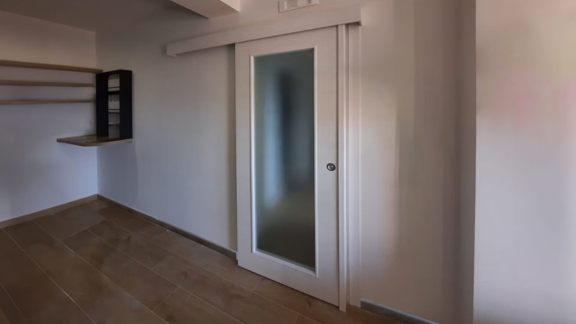 C'è una porta scorrevole in vetro al centro della stanza.