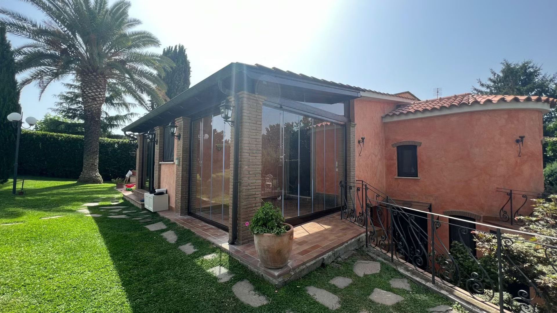 Una casa con molte finestre e una palma sullo sfondo.