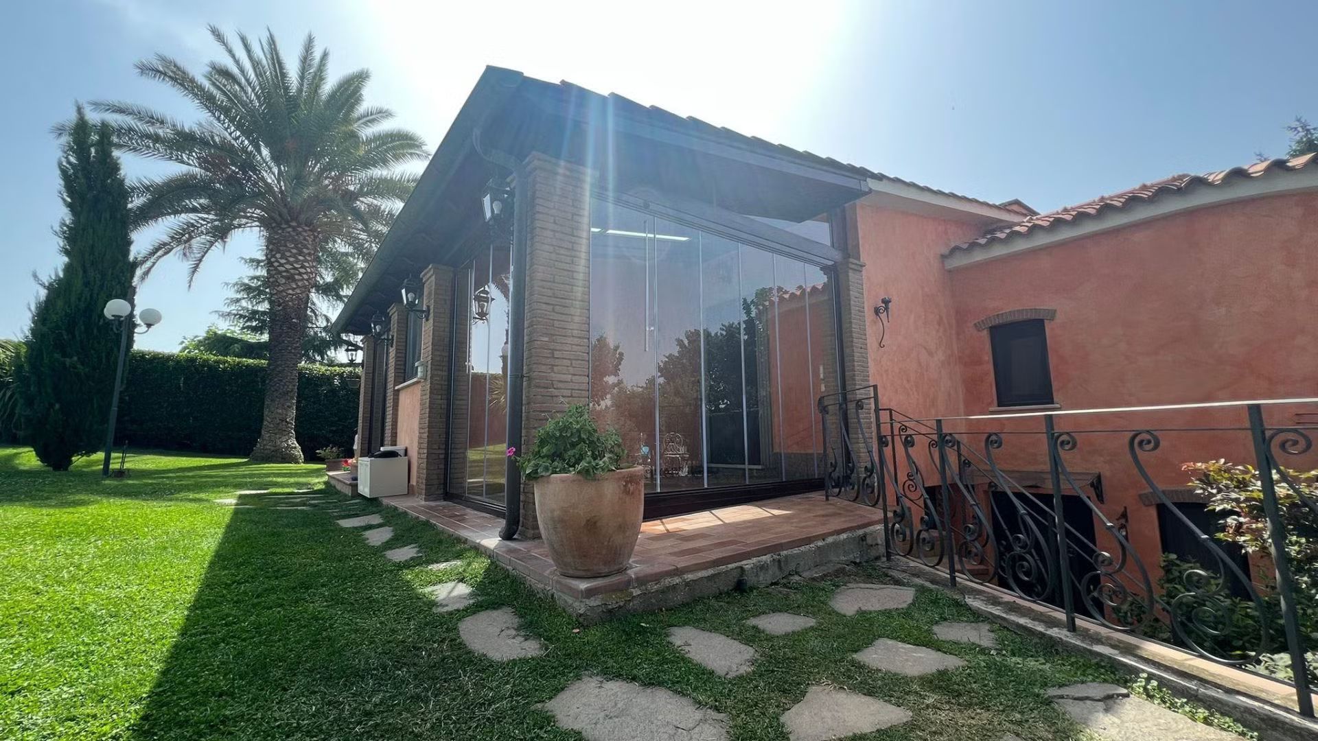 Una casa con molte finestre e una palma sullo sfondo.