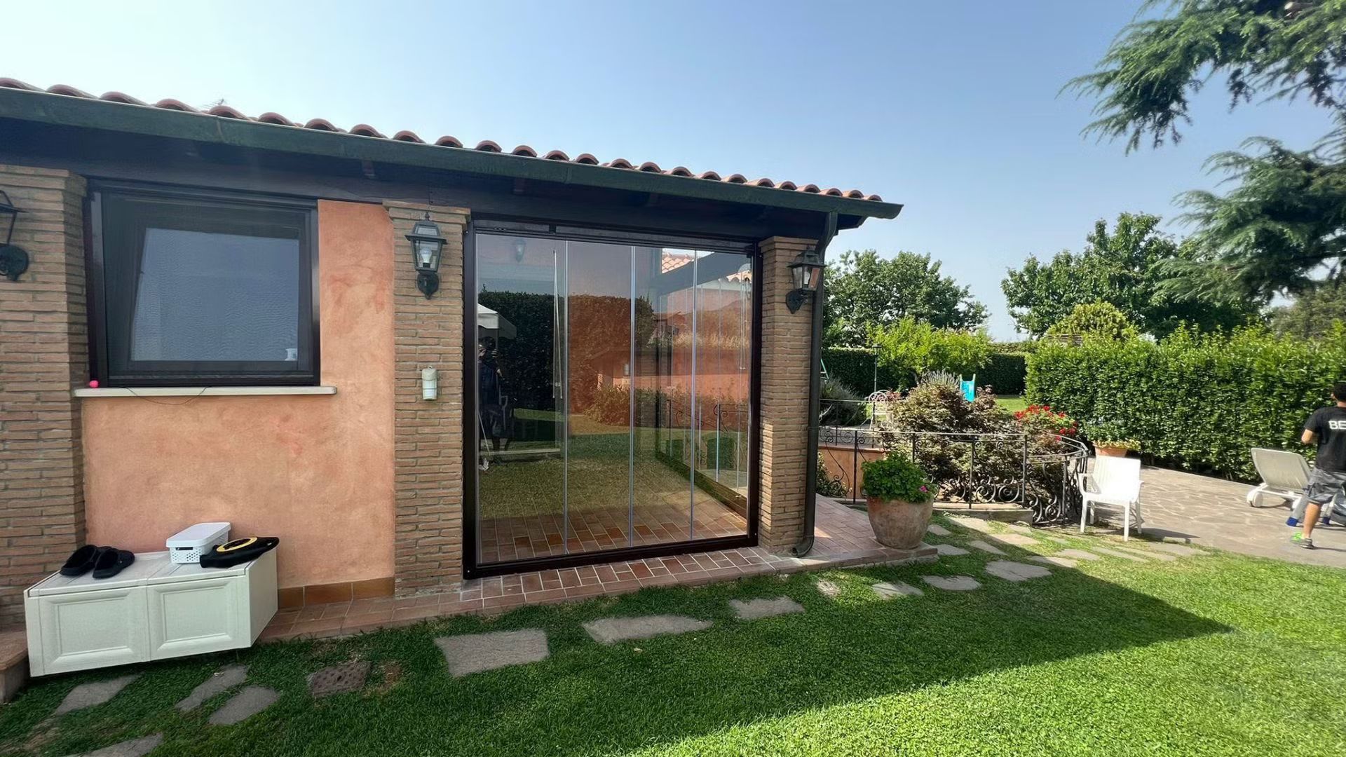 Una piccola casa con una porta scorrevole in vetro nel cortile sul retro.