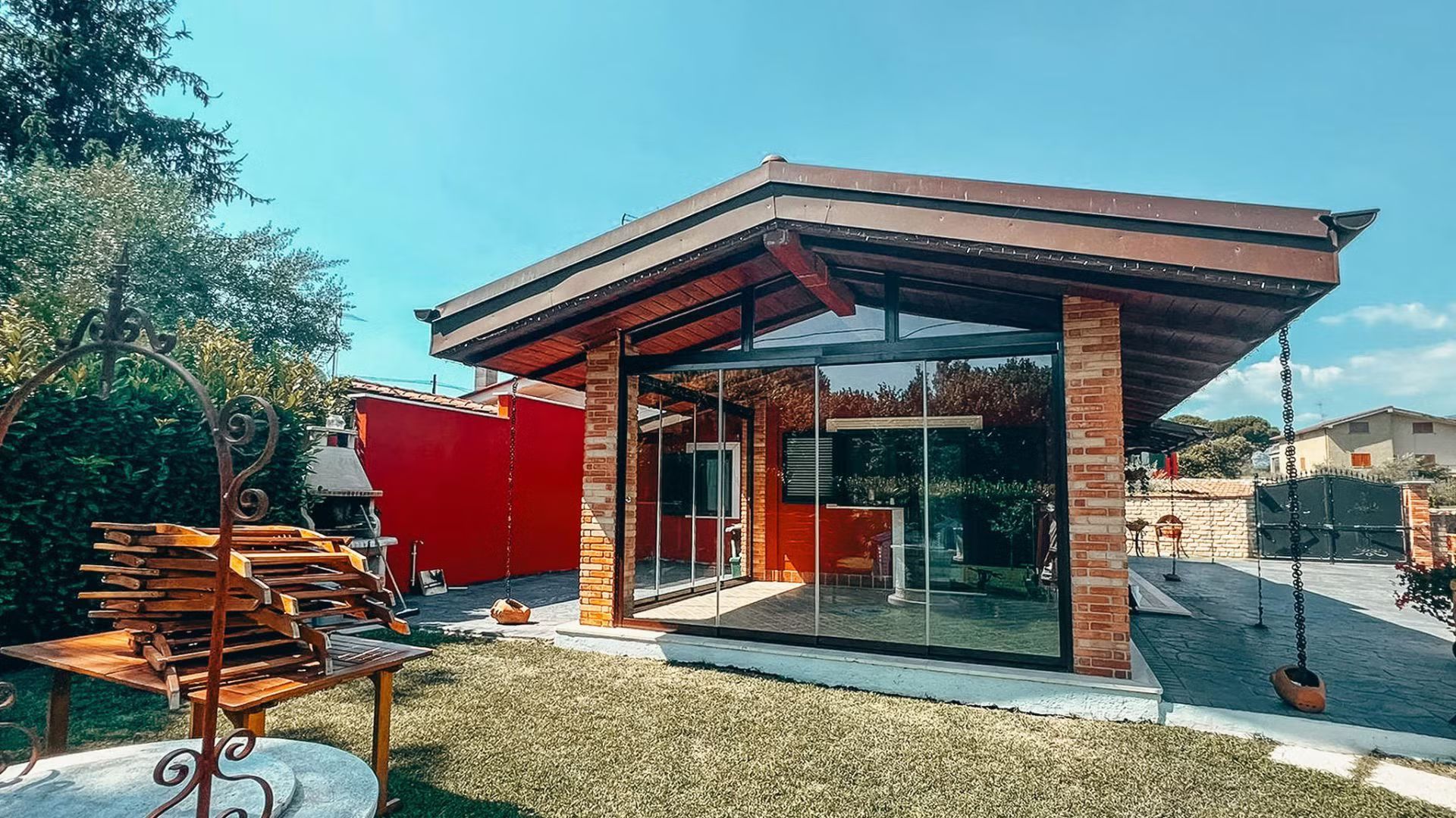 Una piccola casa con il tetto di vetro si trova in mezzo a un rigoglioso campo verde.