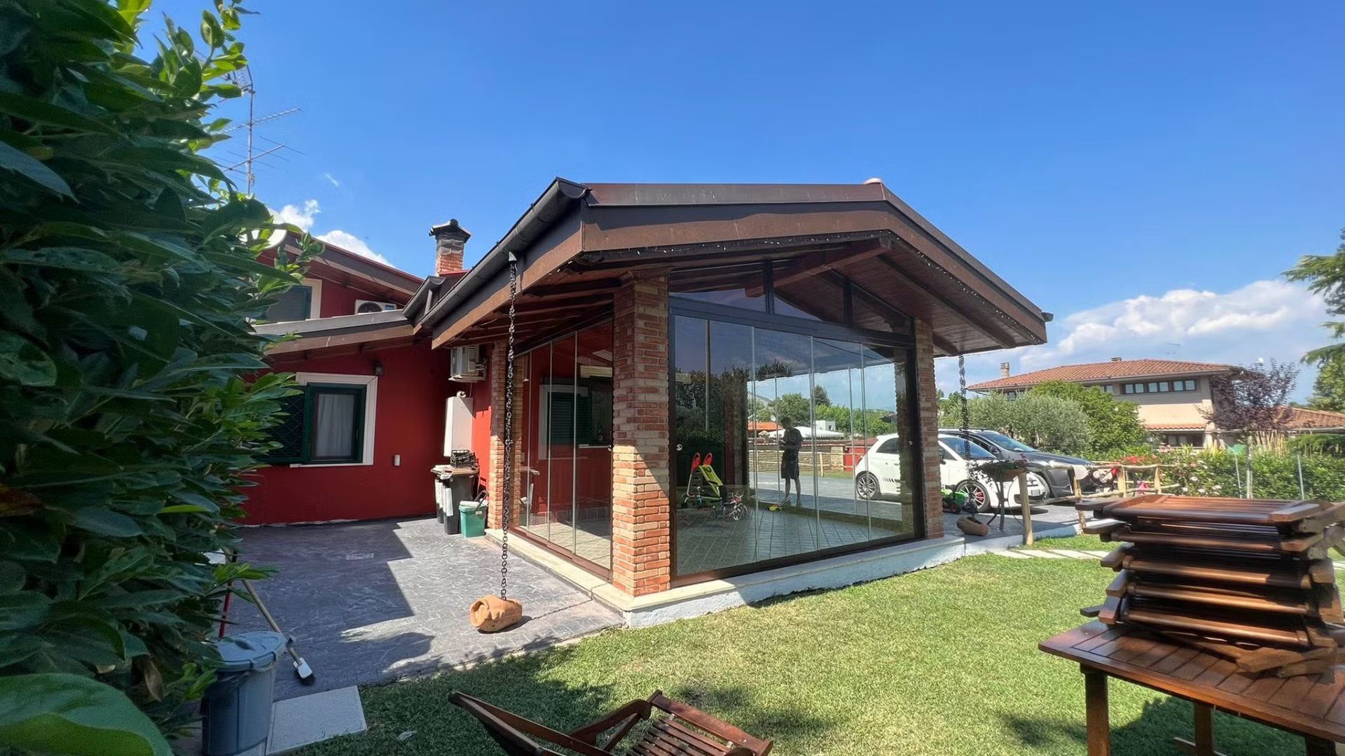 Una casa rossa con una porta scorrevole in vetro nel cortile sul retro.