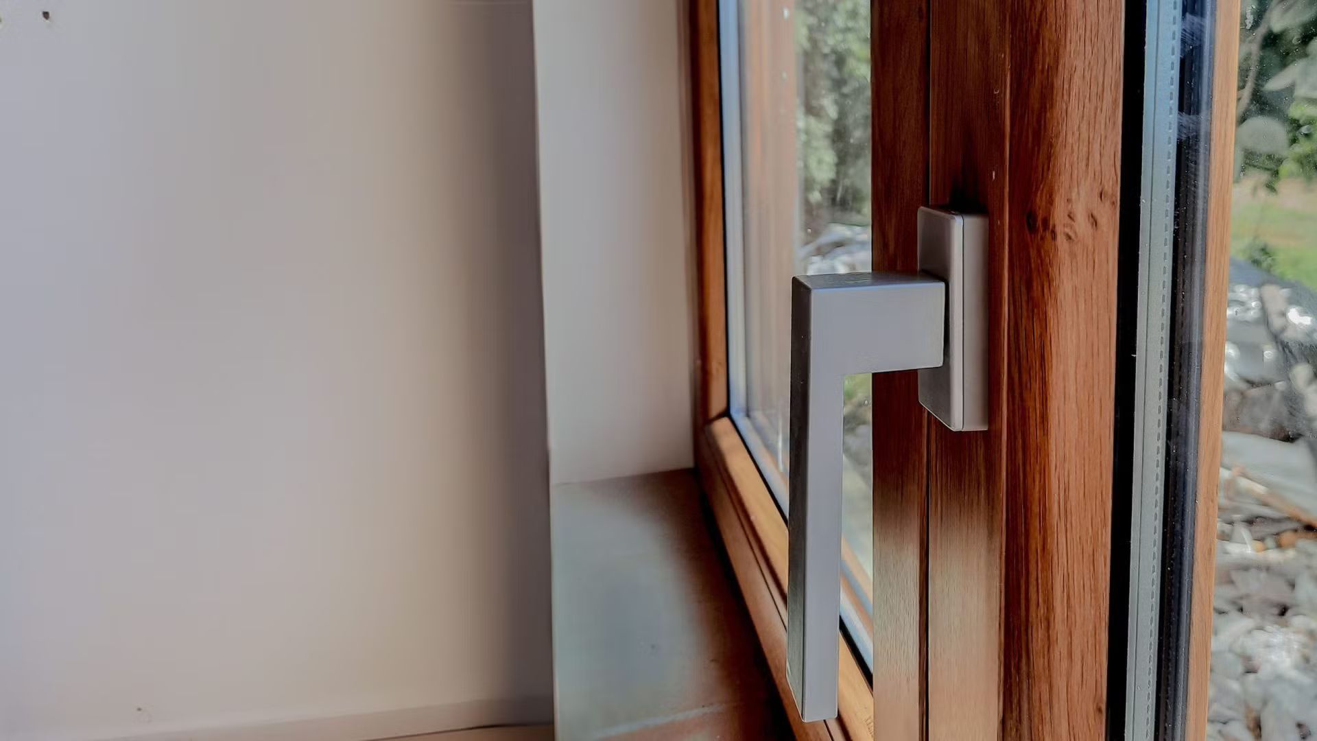 Primo piano di una finestra in legno con maniglia in metallo.