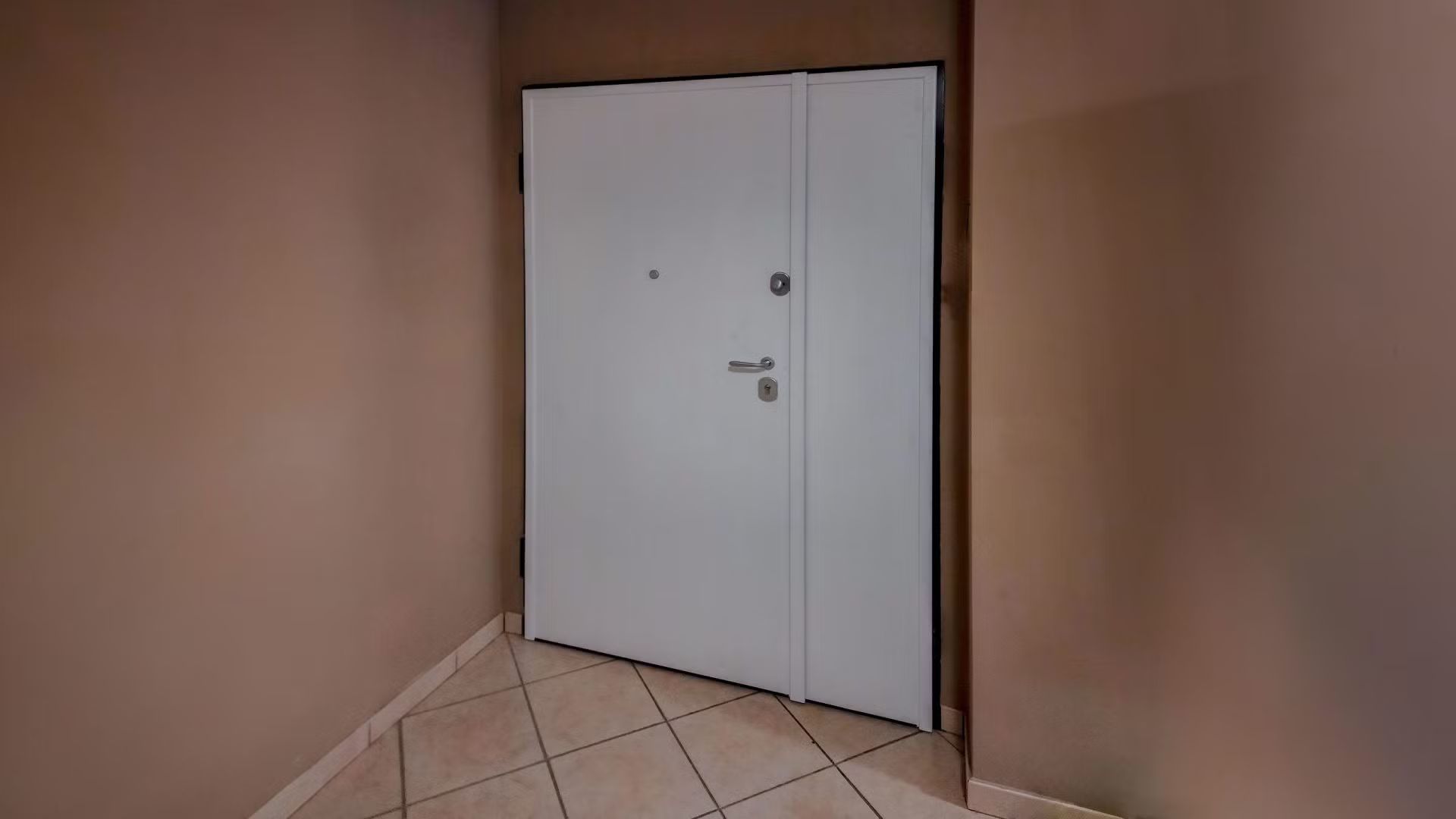 Una porta bianca è aperta in un angolo di una stanza.
