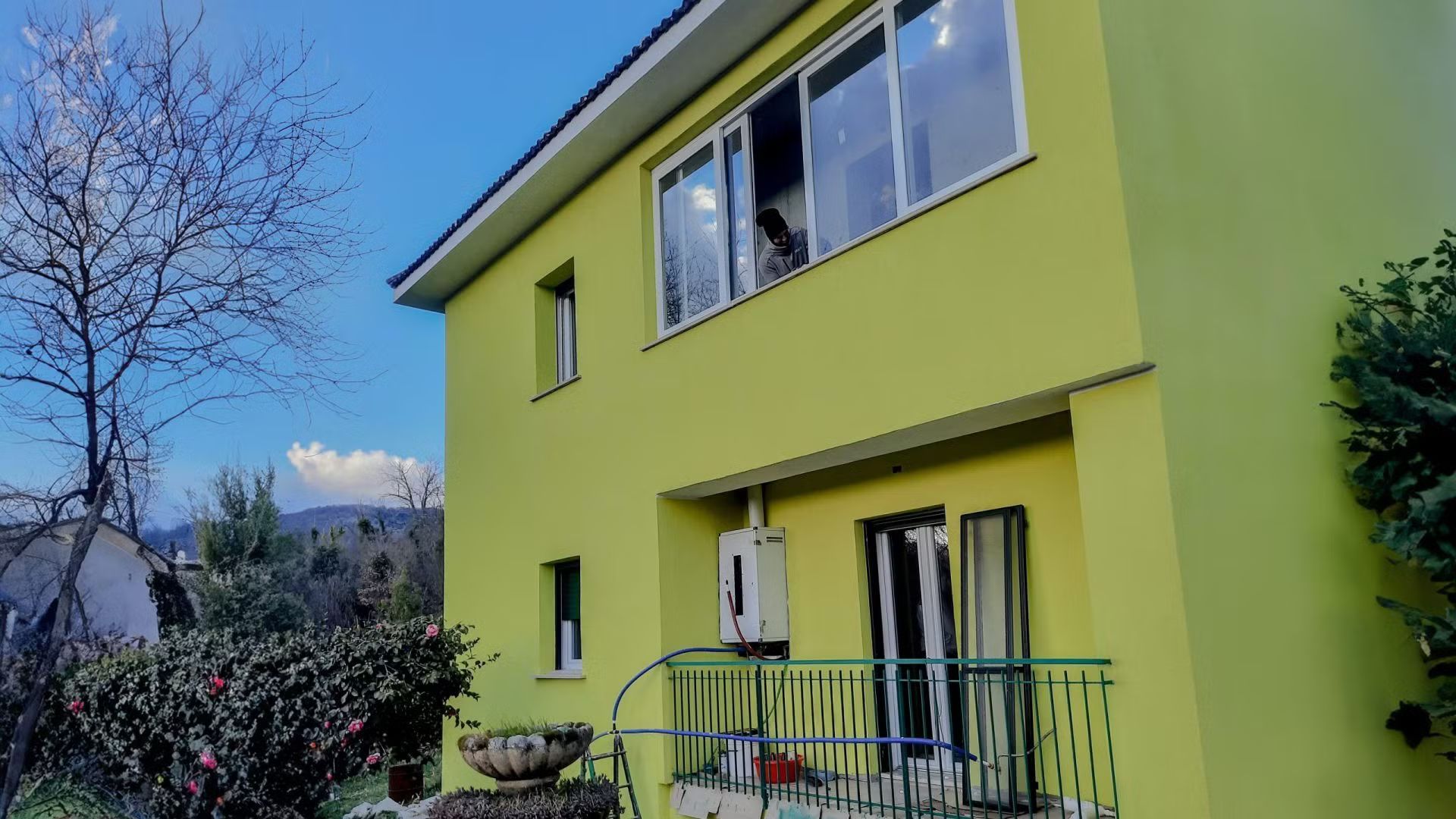 Una casa gialla con un balcone e un cielo azzurro sullo sfondo