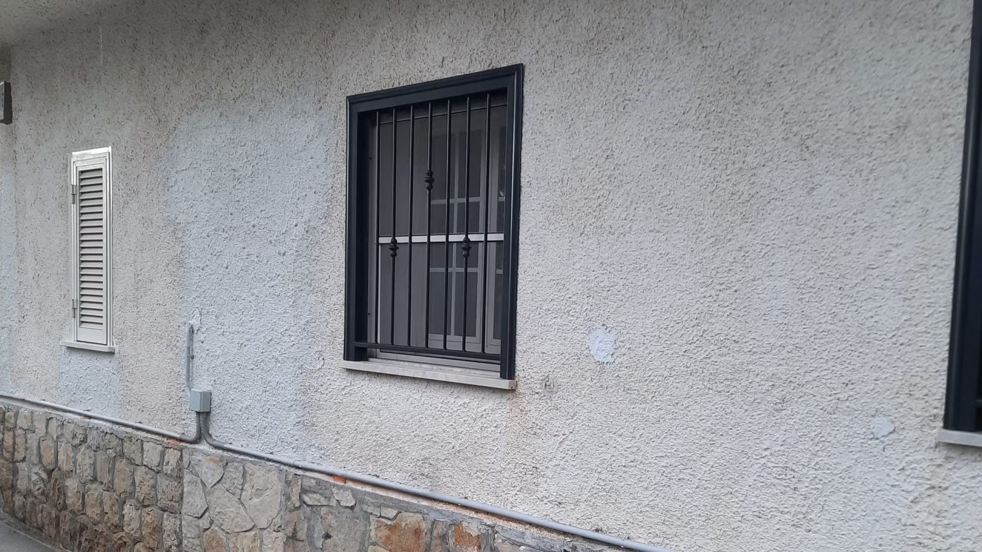 Un edificio con una finestra munita di sbarre.