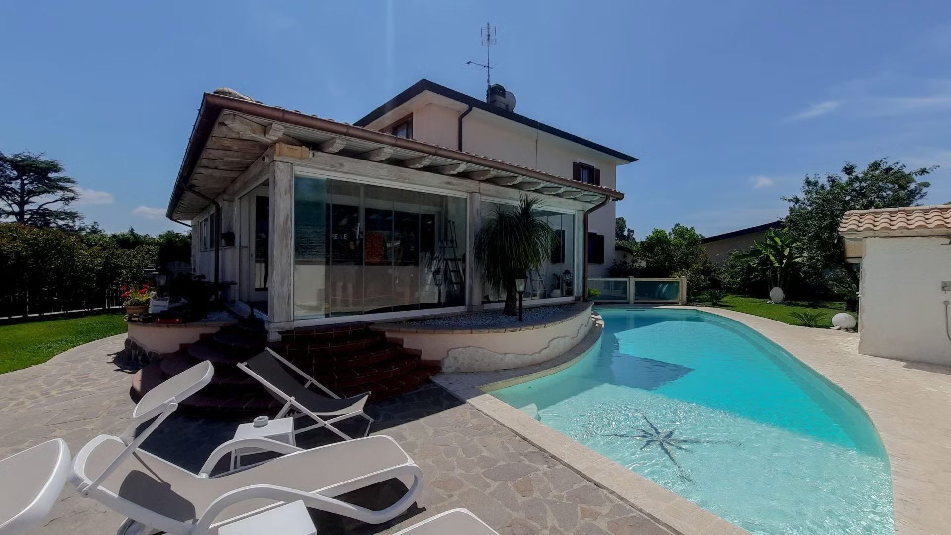 Una casa con una grande piscina di fronte