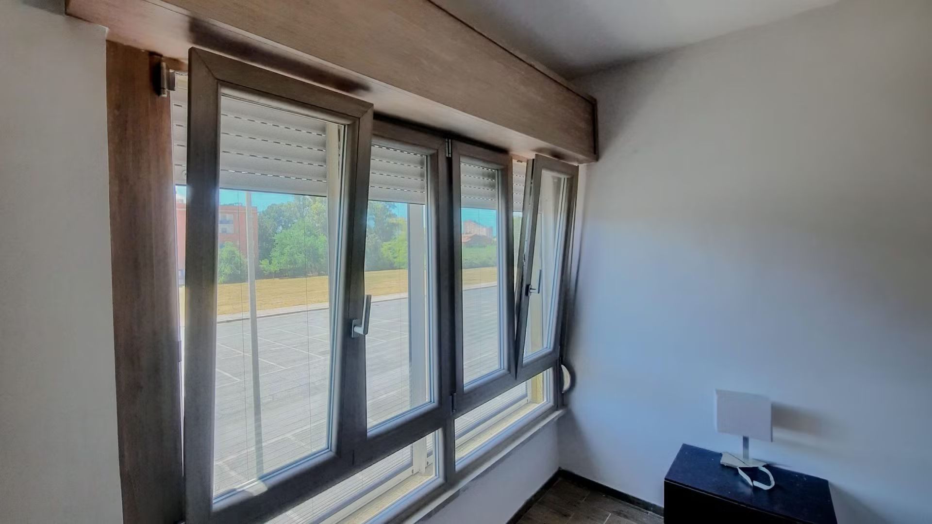 Una stanza con molte finestre e una lampada.