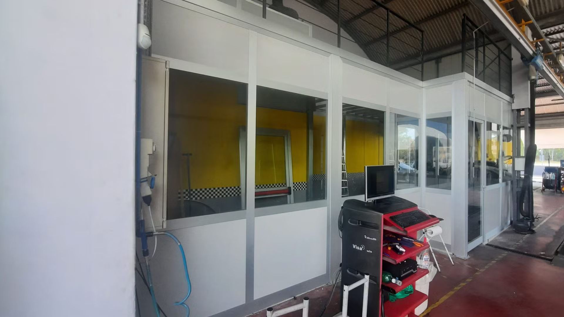 Una grande stanza con molte finestre e un computer su un carrello.