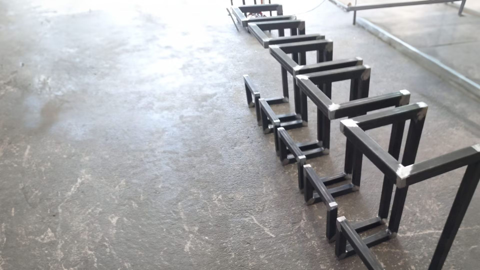 Una fila di telai metallici sono allineati sul pavimento