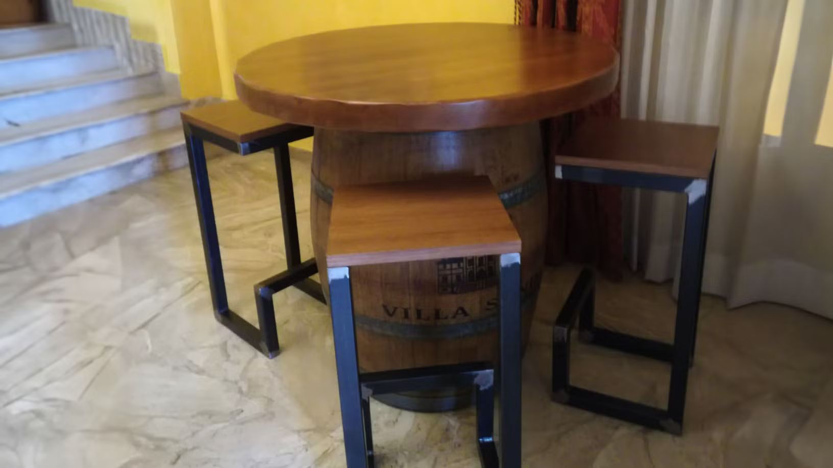 Un tavolo di legno e sgabelli ricavati da una botte di vino.
