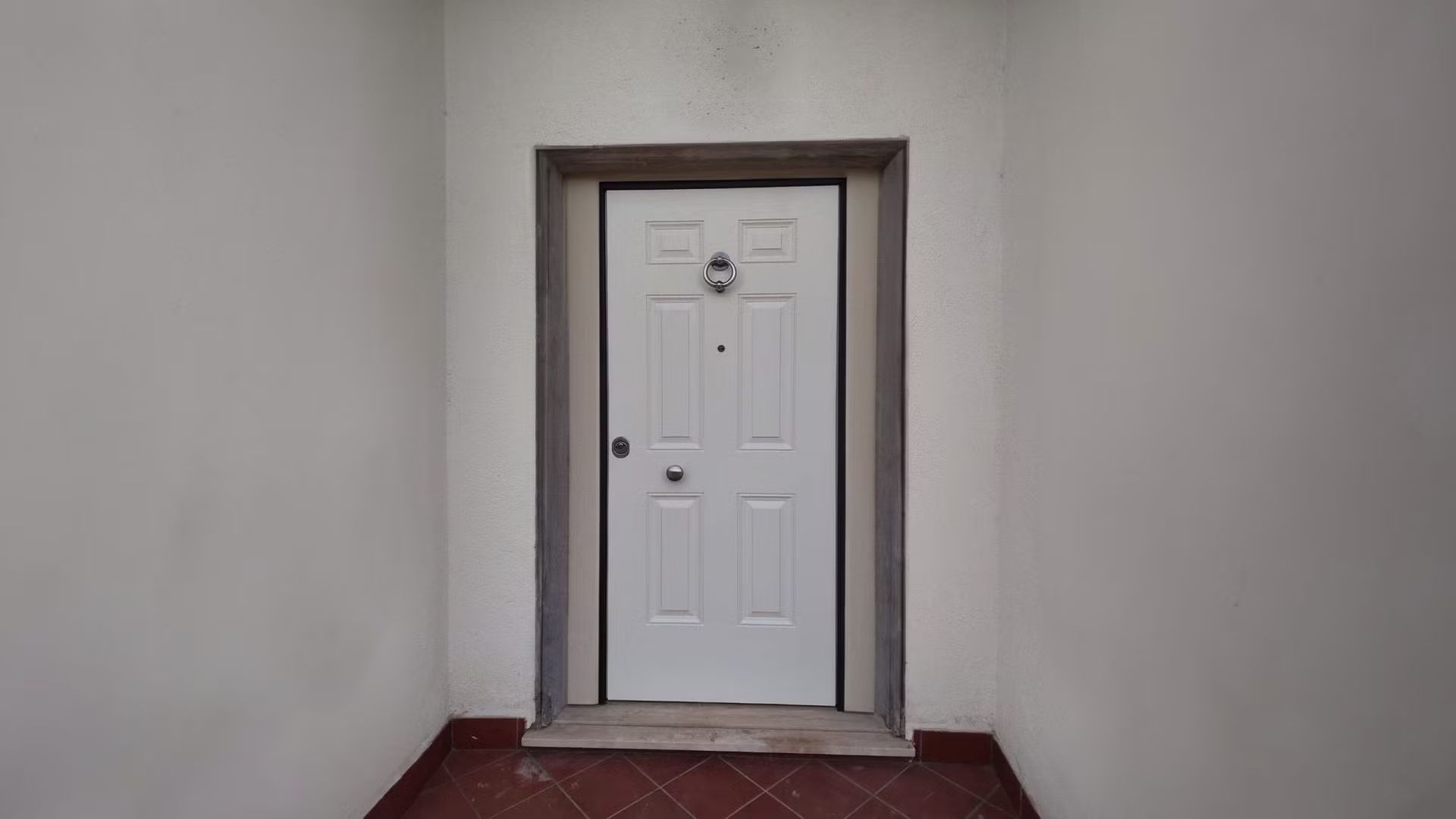 Una porta bianca è posizionata in un angolo di una stanza.