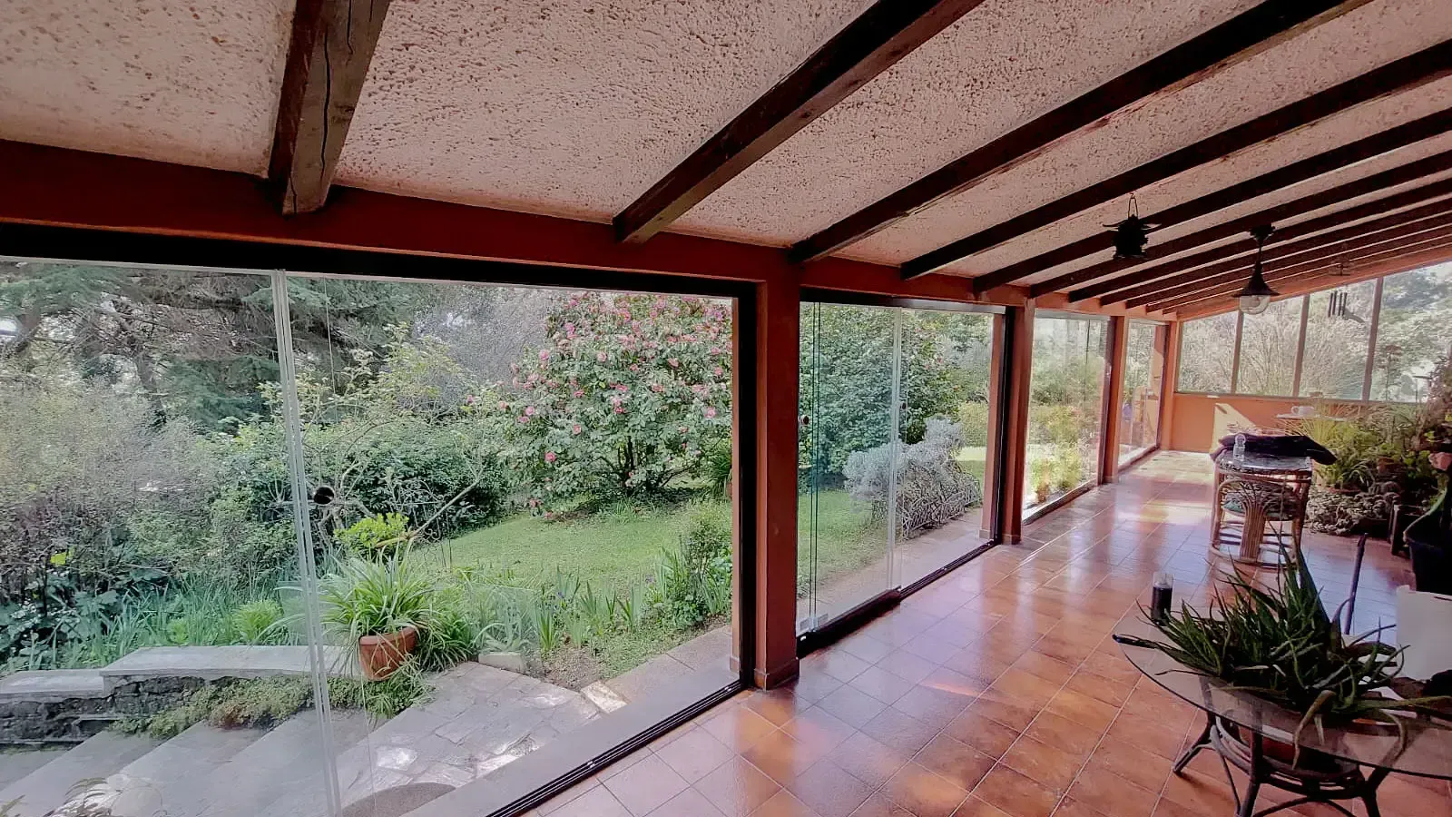 Una grande stanza con molte finestre e vista sul giardino.