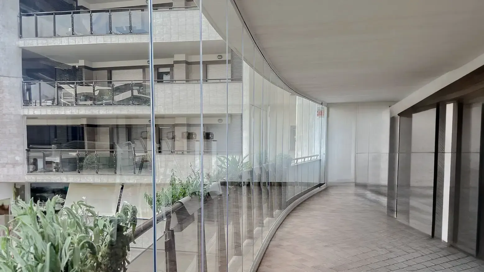 Un grande edificio con un balcone con una porta scorrevole in vetro