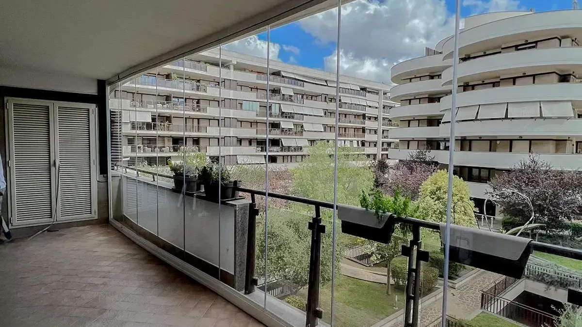 Un balcone con vista su un edificio e sugli alberi.