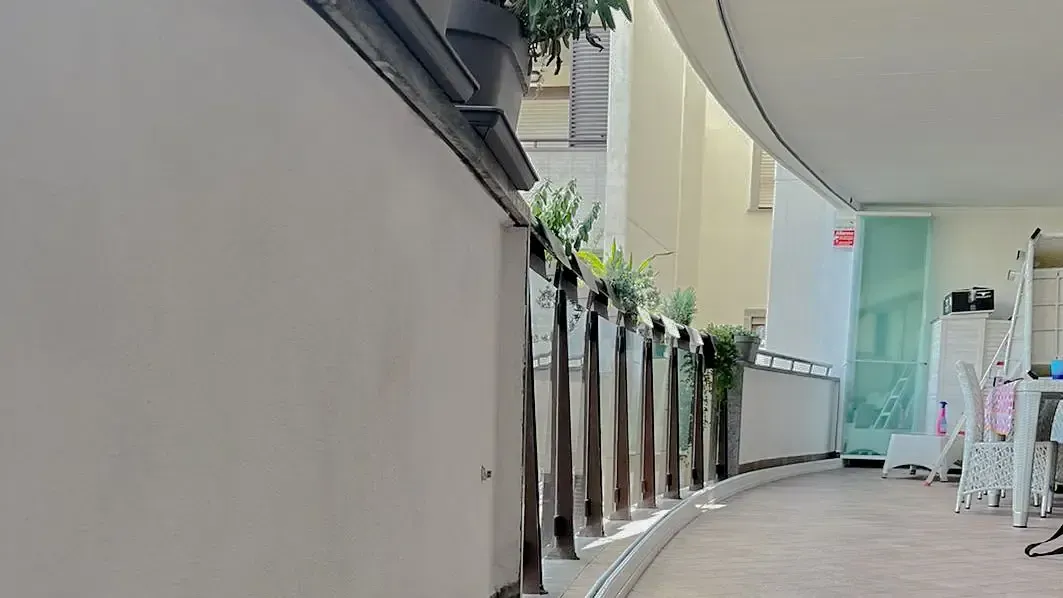 Un balcone con una staccionata di legno e una scala.