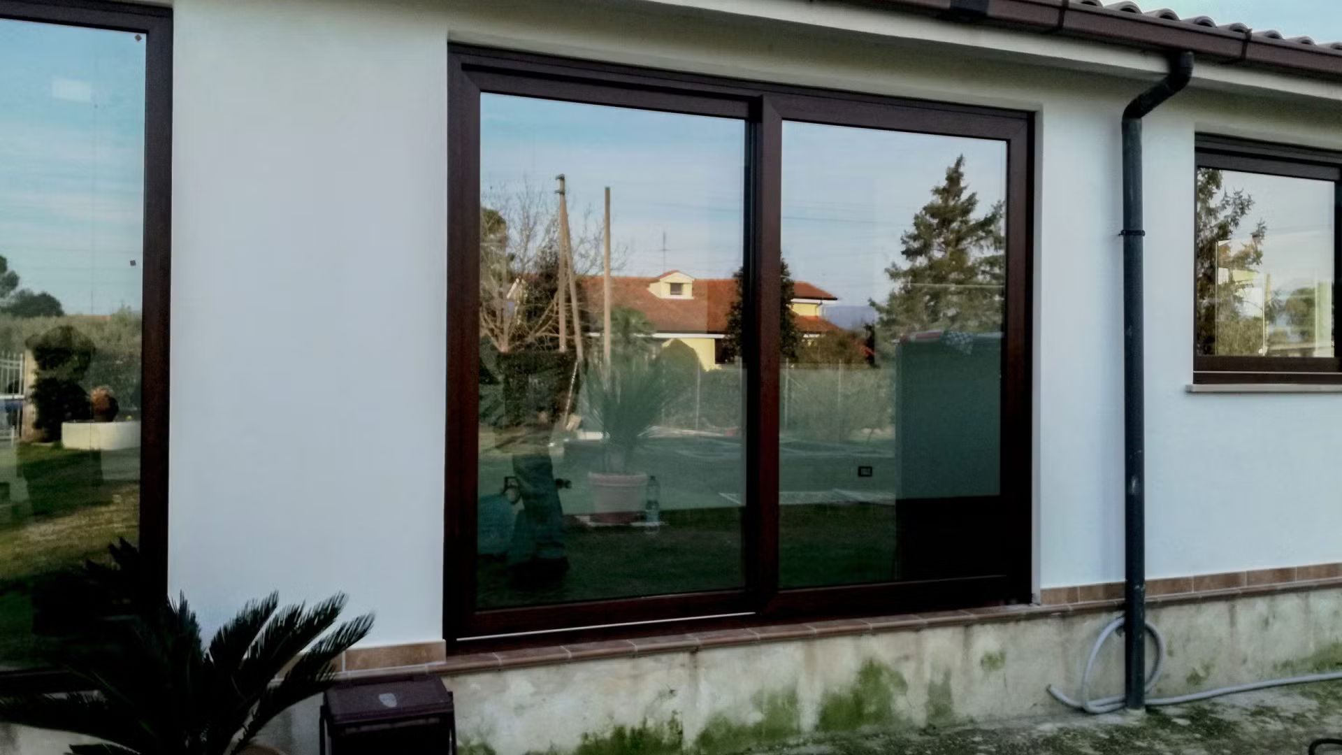 Una casa bianca con tante finestre e una porta scorrevole in vetro.