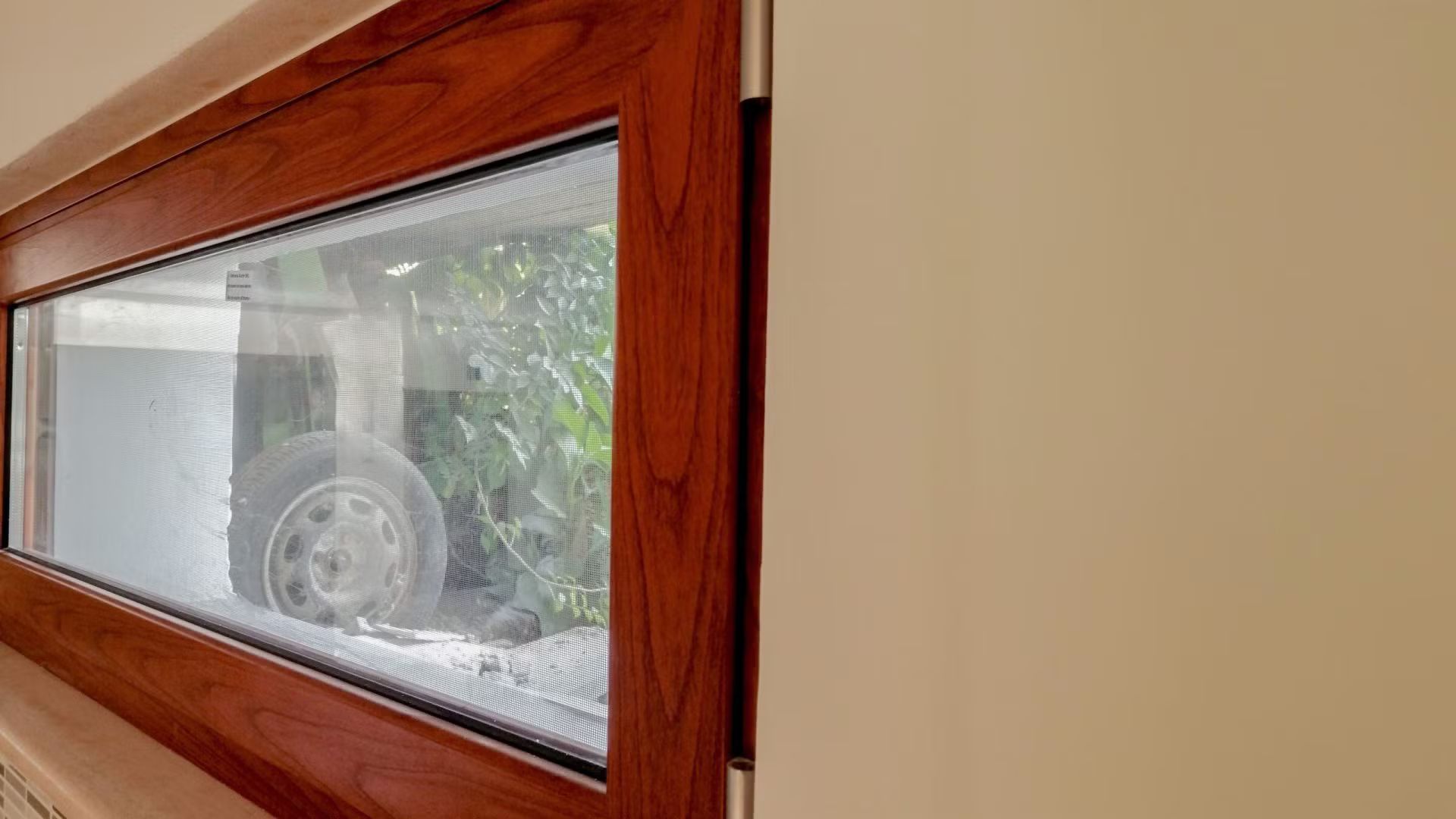 Un'auto è parcheggiata in un garage attraverso una finestra.