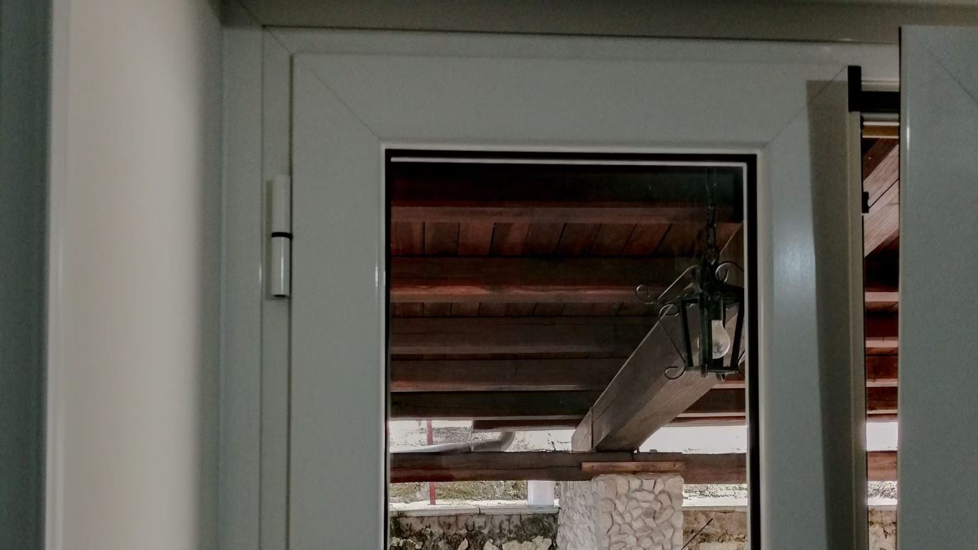 Un primo piano di una finestra con un tetto sullo sfondo.