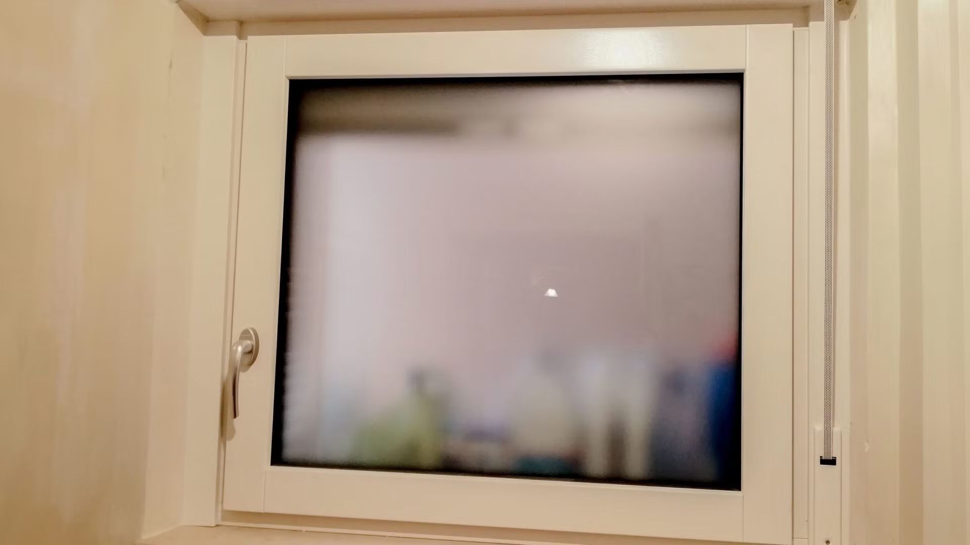 Una finestra bianca con una porta scorrevole in vetro in un bagno.