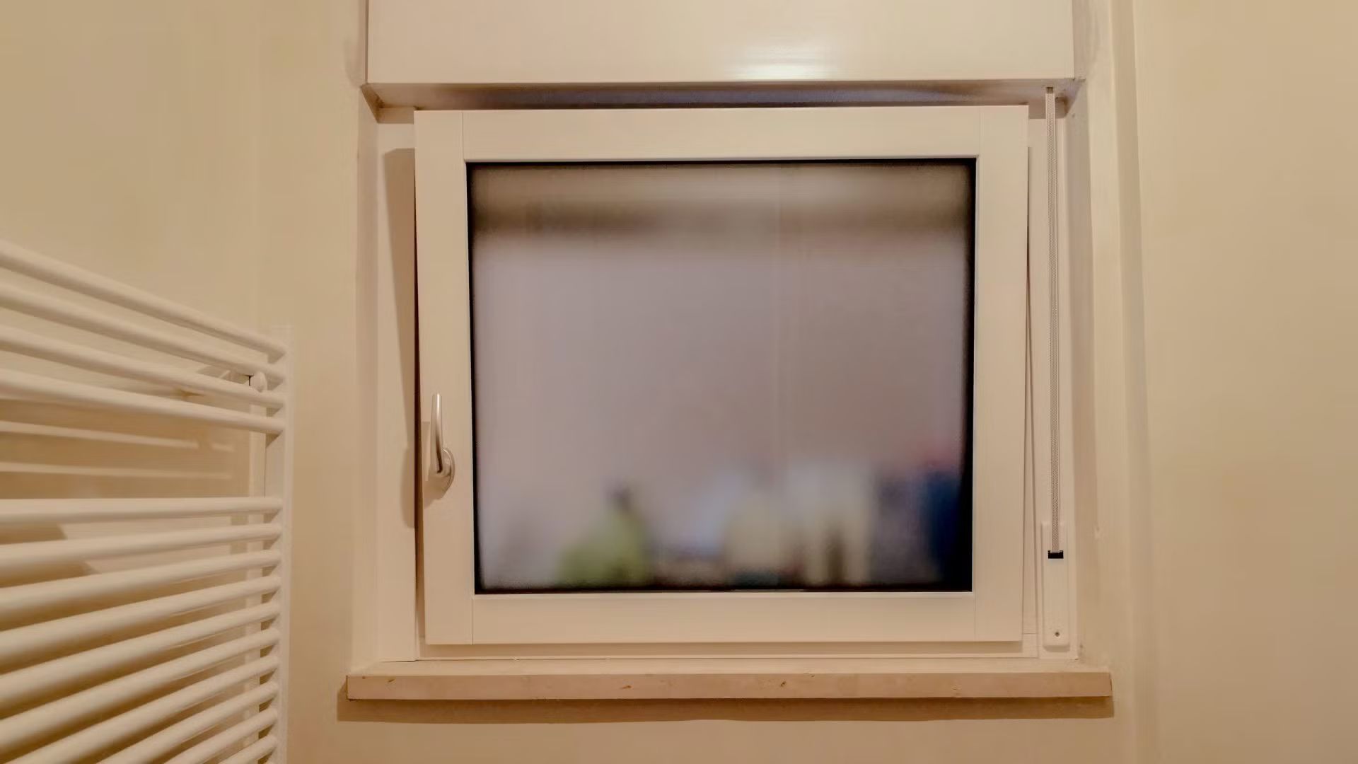 Un bagno con finestra e portasciugamani.