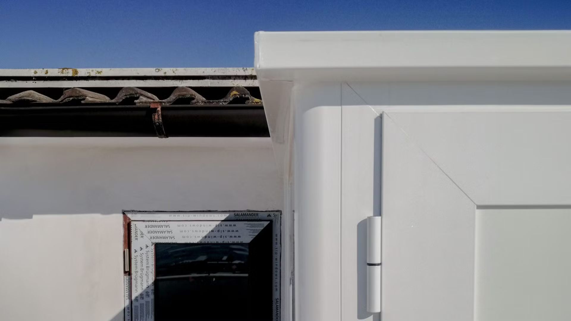 Una porta bianca con un cielo azzurro sullo sfondo