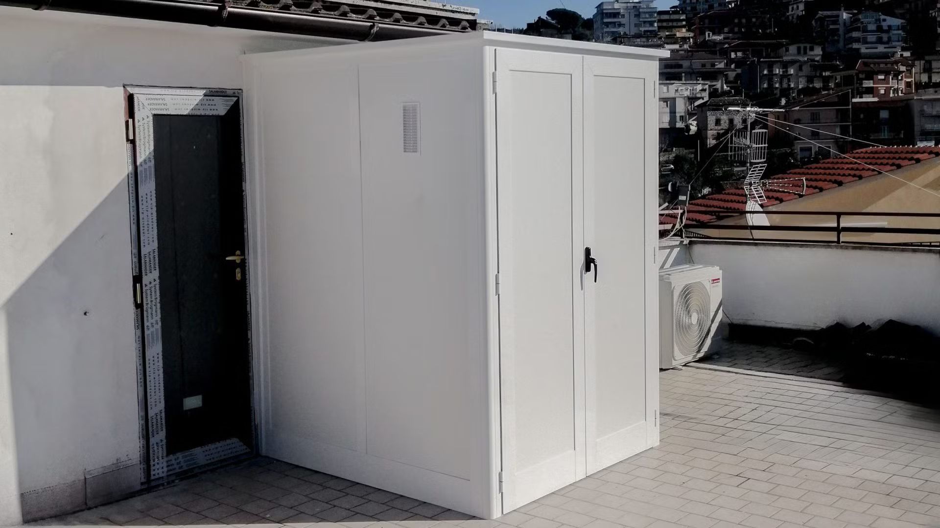 Un piccolo edificio bianco con una porta e un tetto