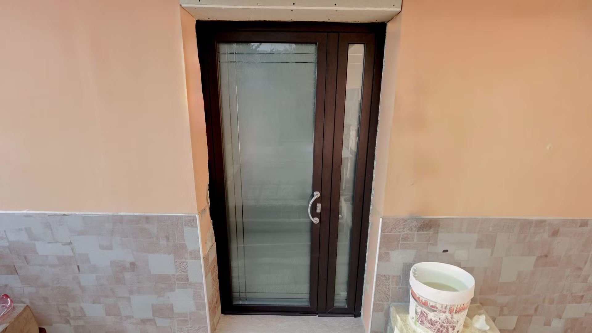 Un secchio bianco è appoggiato su un tavolo vicino a una porta.