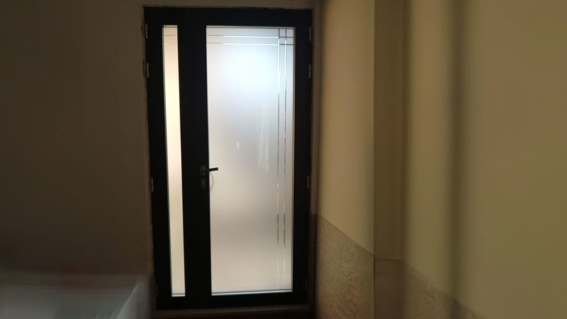 Una porta con una porta scorrevole in vetro in un corridoio.
