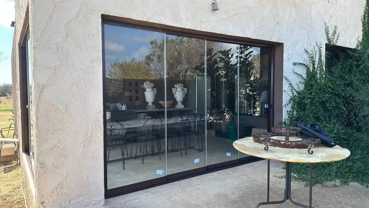 Un tavolo è posizionato di fronte a una grande porta scorrevole in vetro.