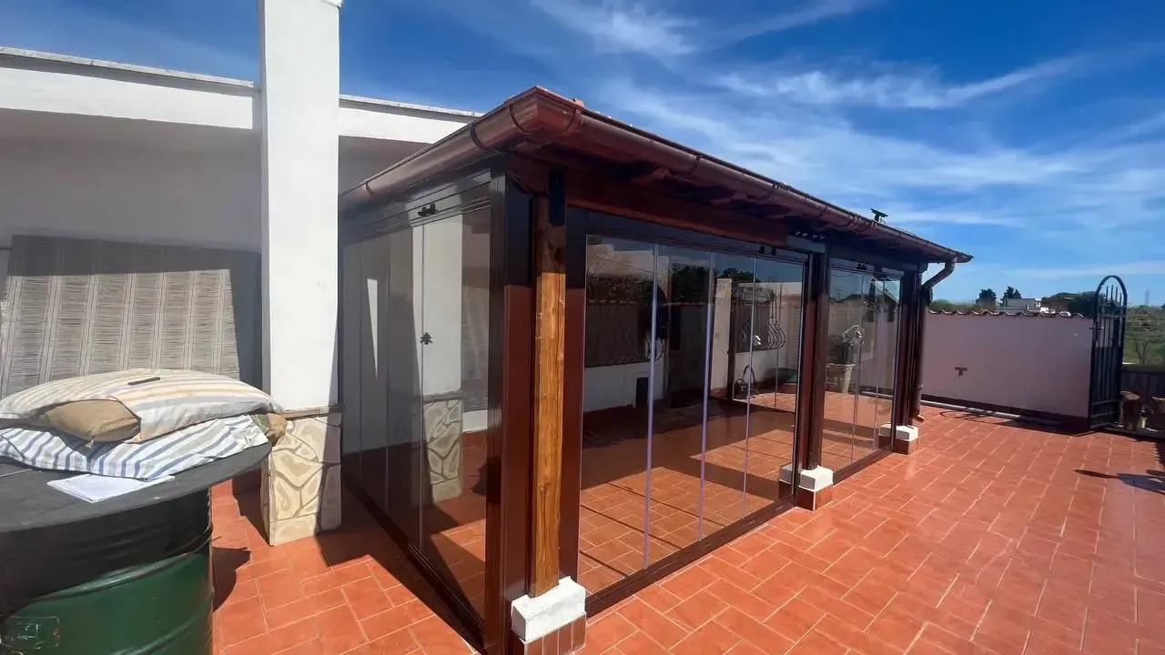 Un patio con pergolato e porte scorrevoli in vetro