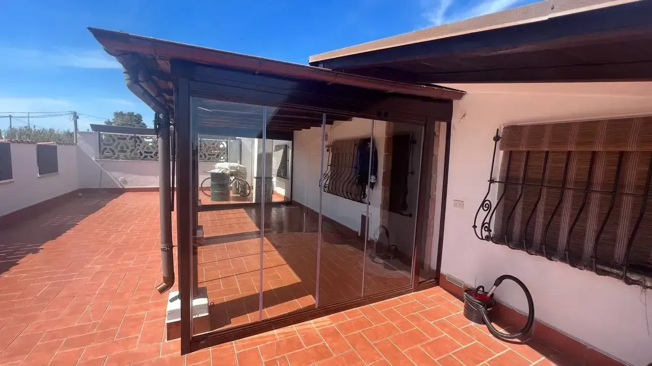 Una casa bianca con una veranda coperta e una bicicletta davanti.