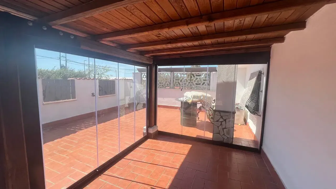 Una stanza con porte scorrevoli in vetro e soffitto in legno.