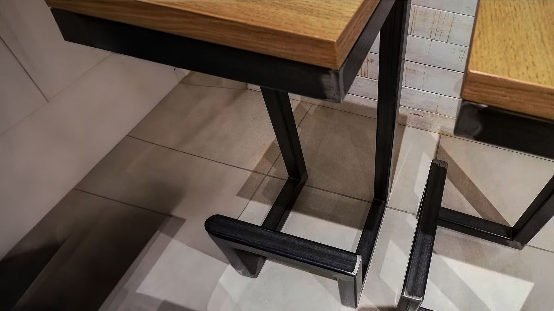 Primo piano di un tavolo di legno con struttura in metallo.