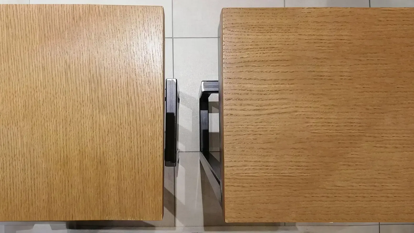 Due scatole di legno sono appoggiate una accanto all'altra su un pavimento piastrellato.