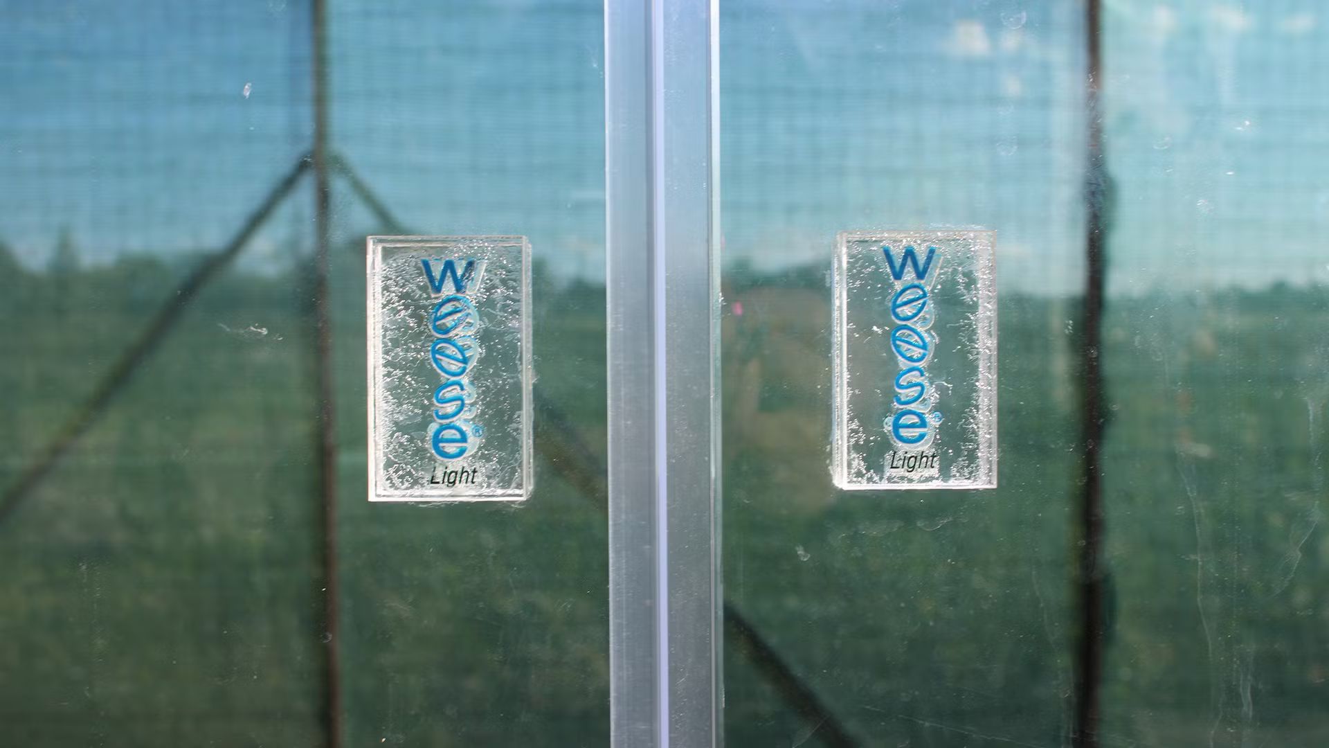 Un primo piano di una porta in vetro con due adesivi.