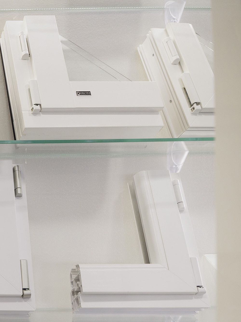 Un primo piano della cornice bianca di una finestra su una mensola di vetro.