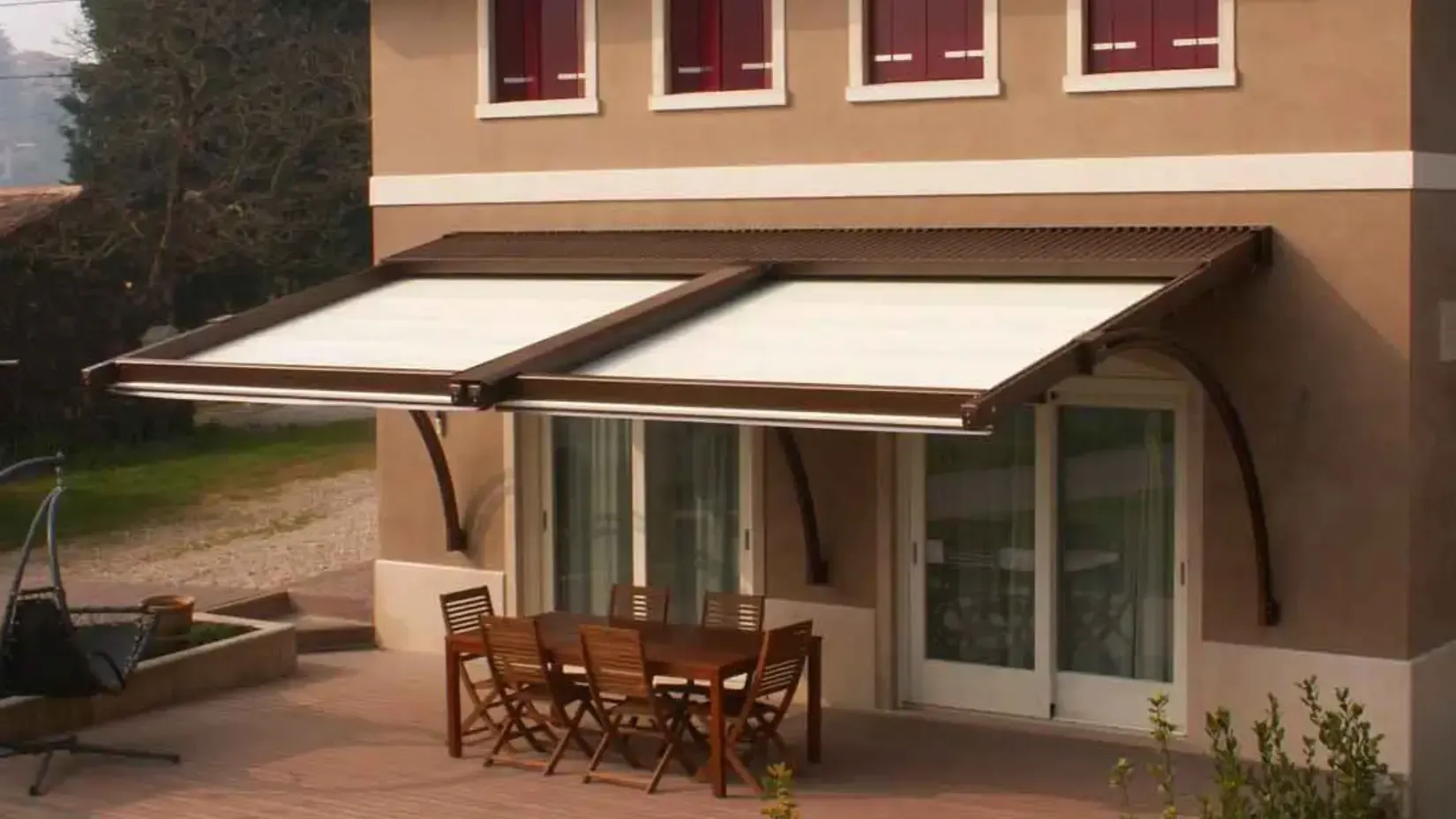 Una casa con un tavolo e delle sedie sotto una tenda da sole