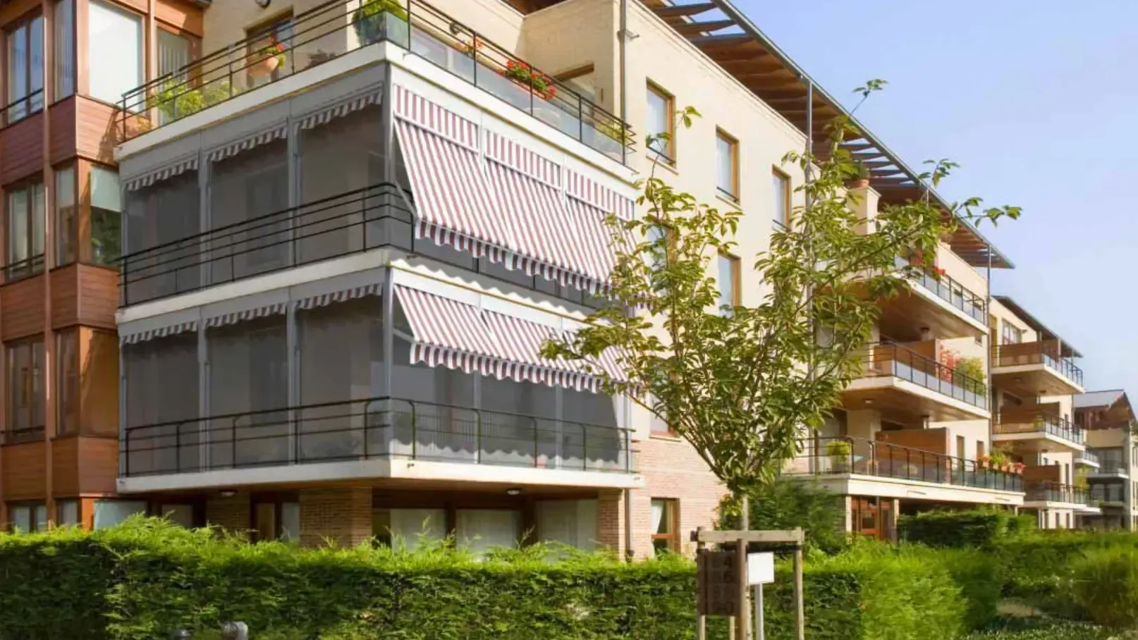 Un grande condominio con molti balconi e tende da sole