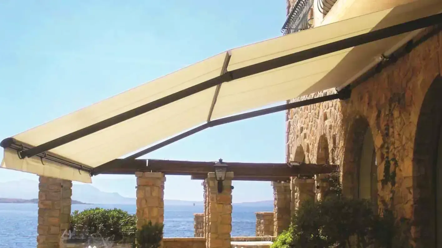 Una grande tenda da sole copre un balcone che si affaccia sull'oceano.