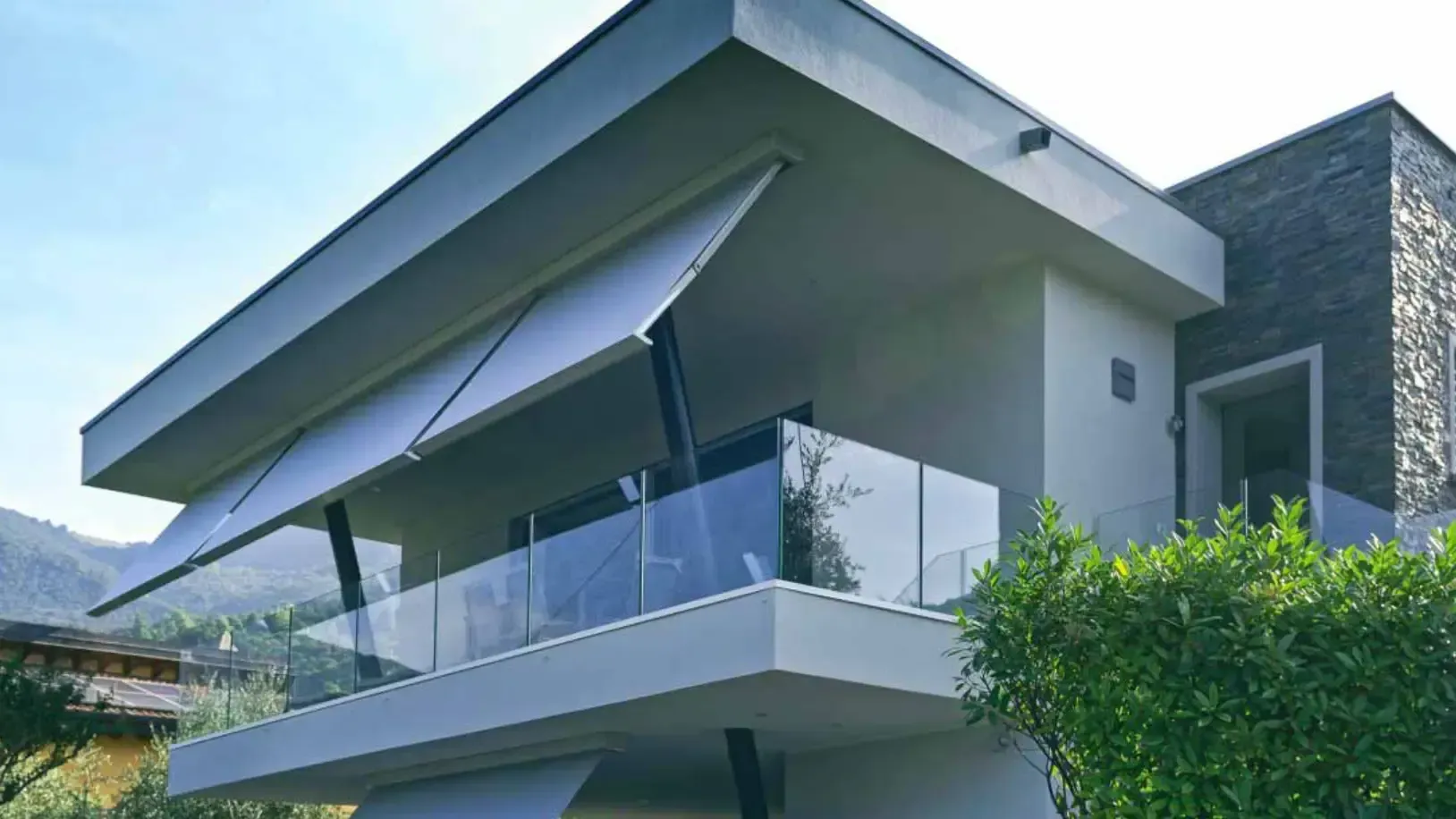 Una casa moderna con un balcone coperto da una tettoia