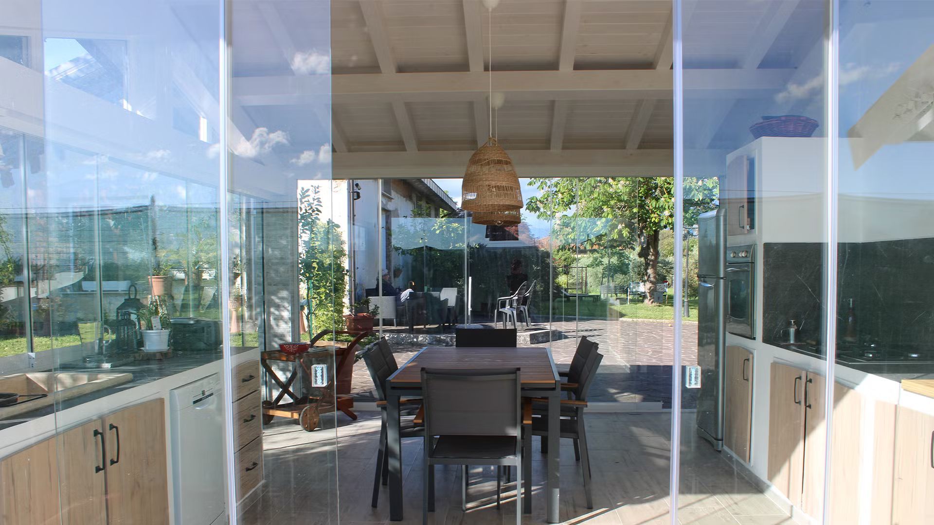 Una sala da pranzo con un tavolo e sedie dietro una parete di vetro.