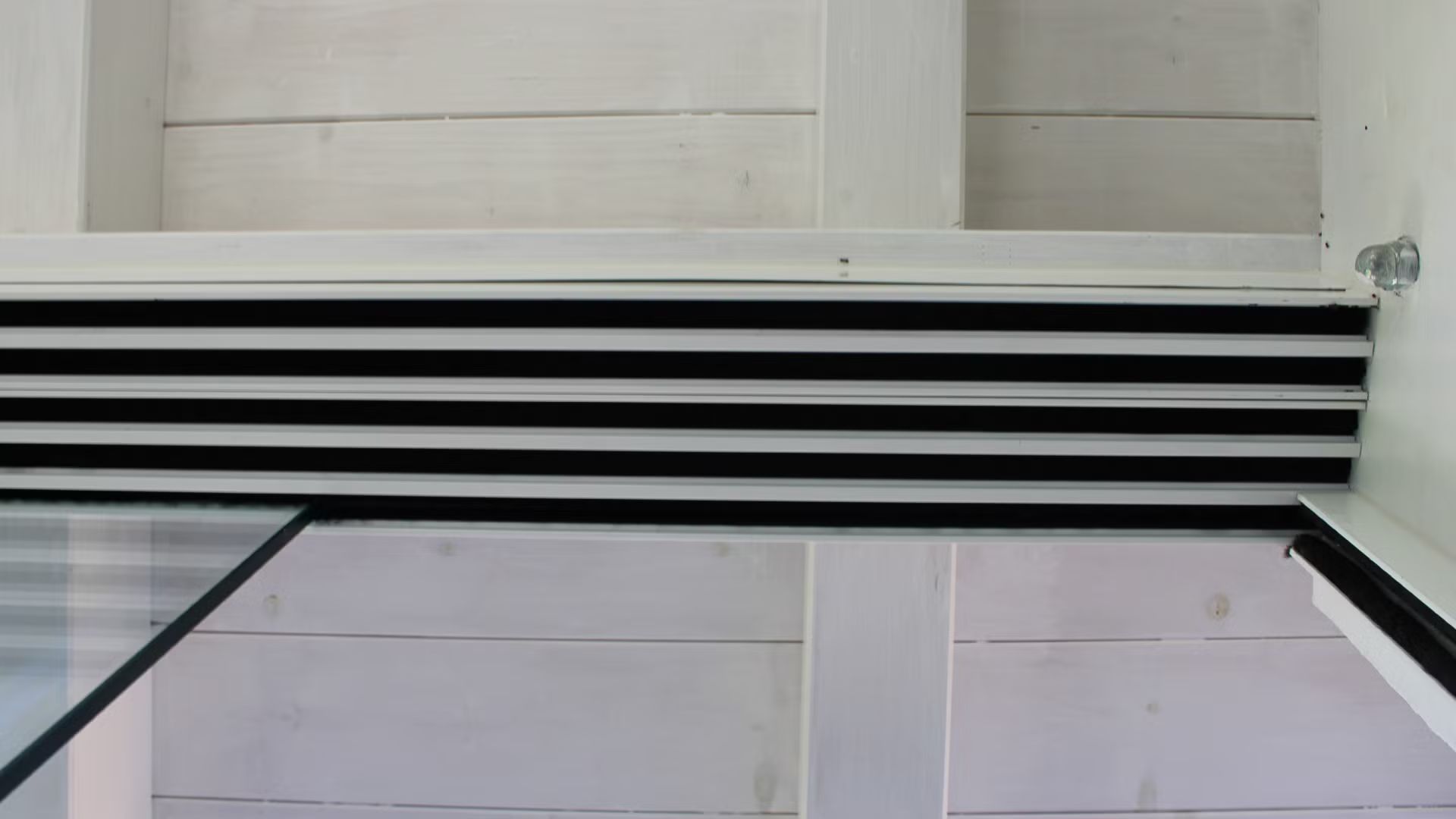 Un primo piano di una porta scorrevole in vetro in una stanza.