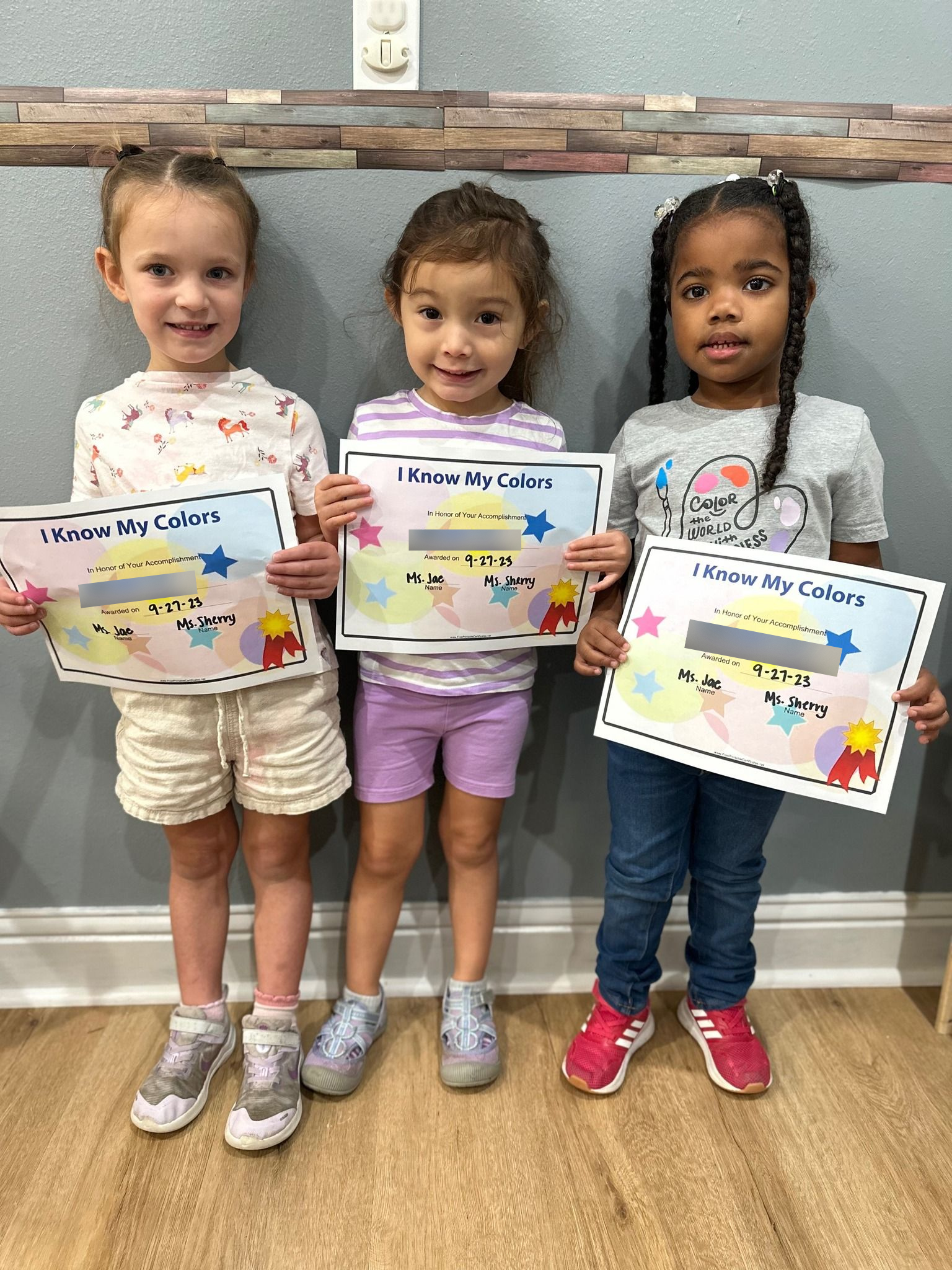 three little girls are standing next to each other holding certificates
