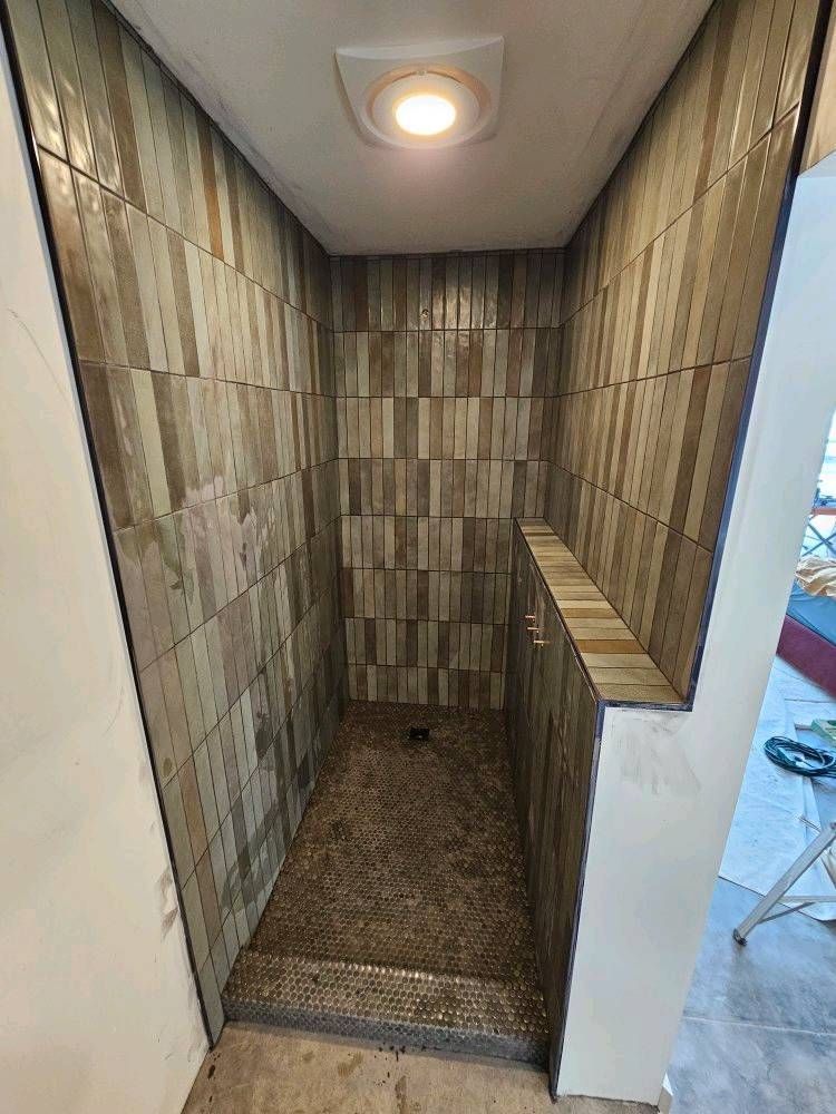 A bathroom with a walk in shower and a shelf.