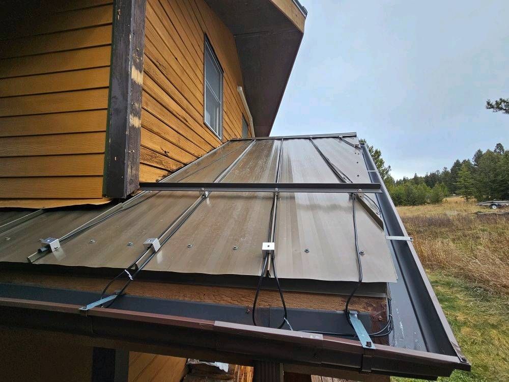 A house with a metal roof and a gutter on the side of it.