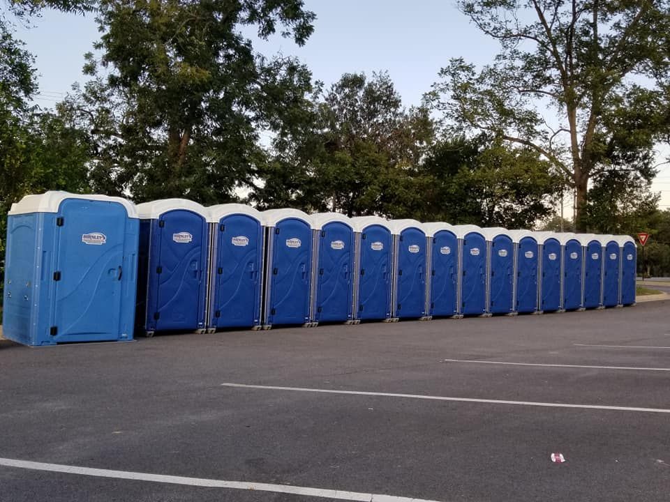 A set of blue porta potty toilets on a trailer ready to be shipped to an event.