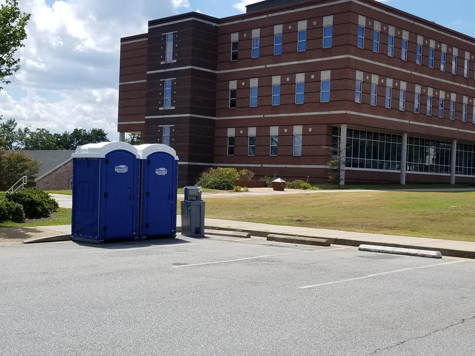 Mobile toilets are lined up outside.