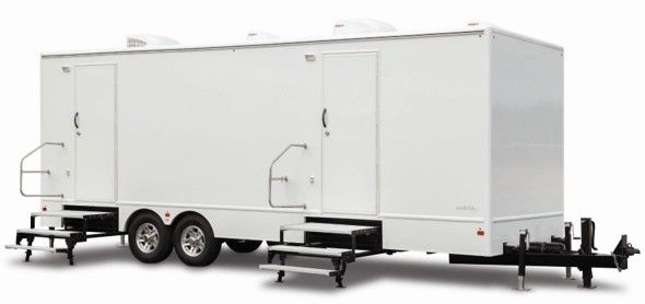 White dual-axle enclosed trailer with side doors and rear ramp stairs on a plain background White dual-axle enclosed trailer with side doors and rear ramp stairs on a plain background