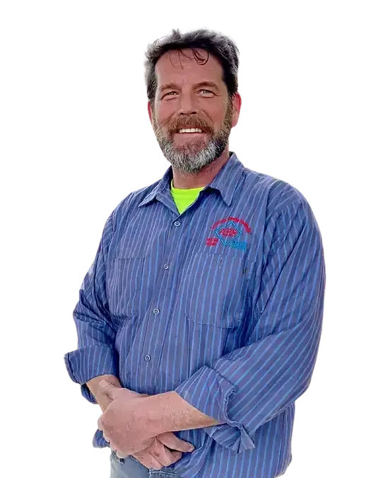 A man with a beard is wearing a blue striped shirt and smiling.